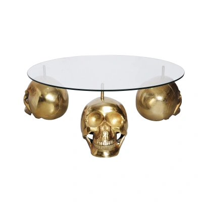 Estila Designový kulatý konferenční stolek Hamlet se třemi nožičkami ve tvaru lebek ve zlaté barvě a skleněnou vrchní deskou 90 cm